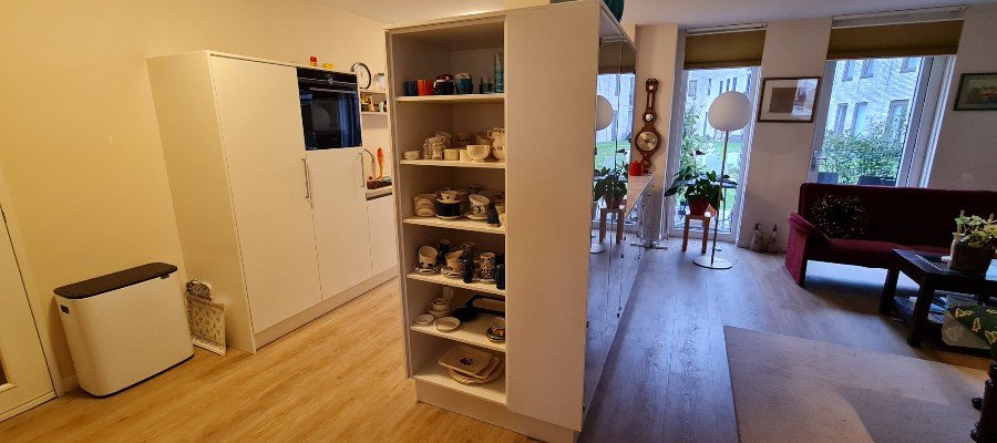 Keuken op maat met een natuurstenen blad en uitbreiding naar de woonkamer